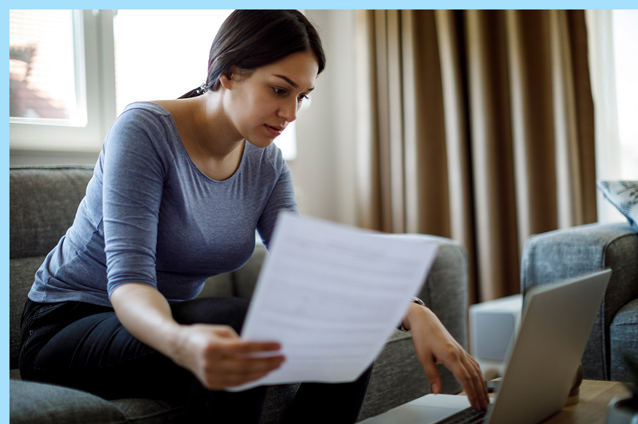 adult overlooking paperwork in her living room