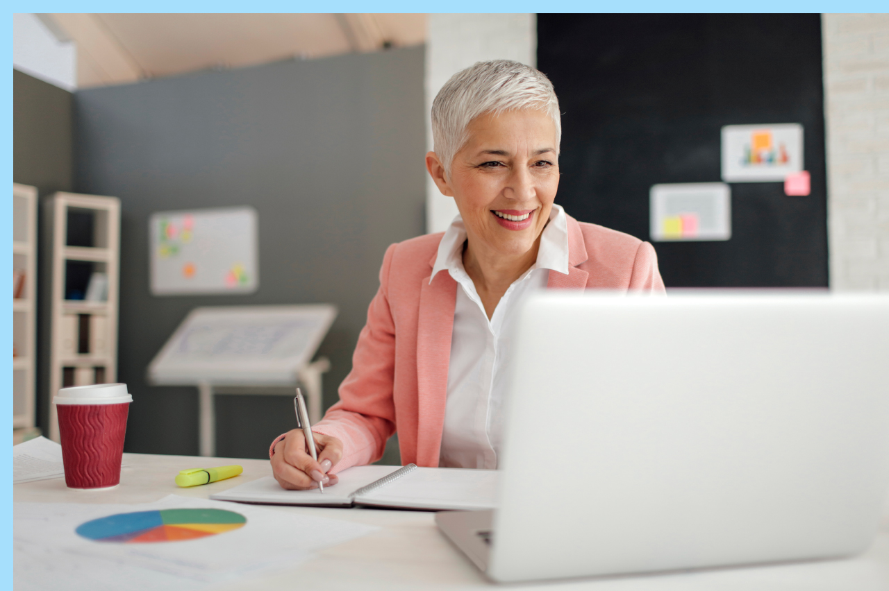 older woman looking at files oner her computer and taking notes